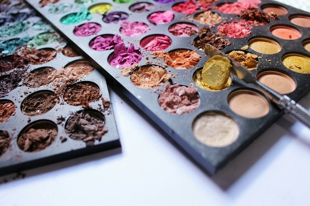 Öppna makeup-paletter med färgglada, delvis använda ögonskuggor